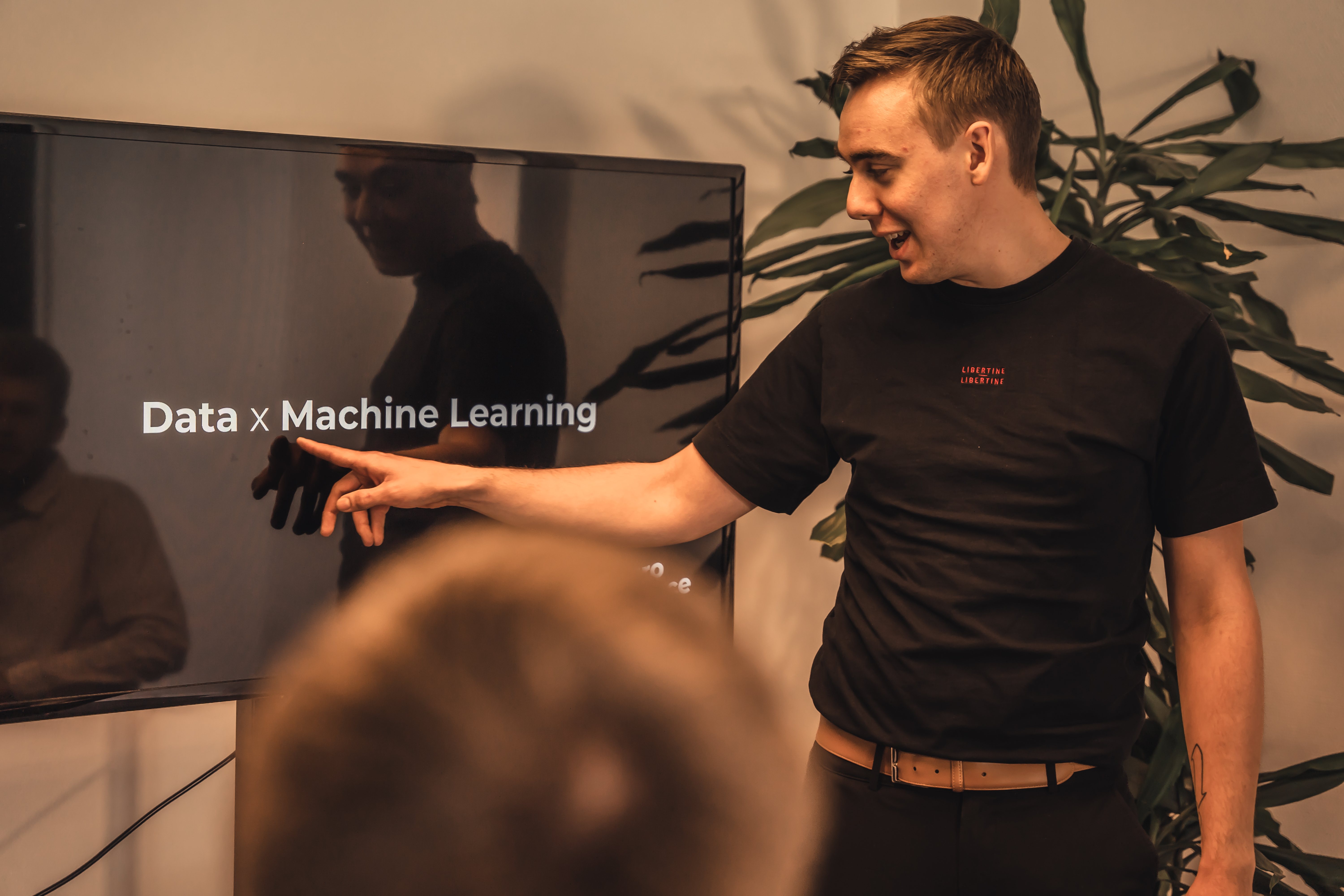 Data Engineer pointing at a screen saying ‘data x machine learning’